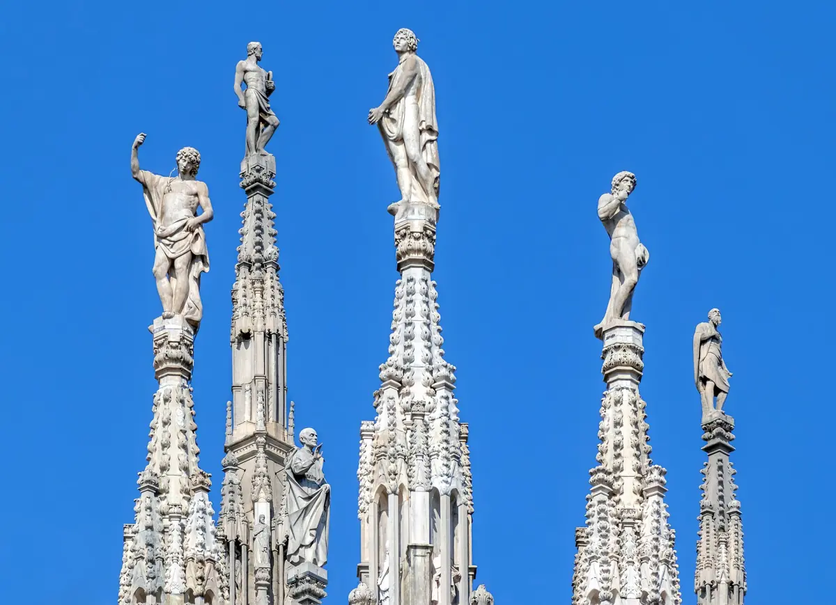 Spires topped by statues against a blue sky